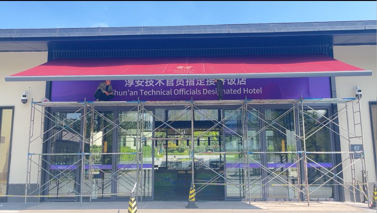 2022杭州亚运度假村2-12地块室外雨棚项目实景:淳安技术官员指定接待饭店主入口红色伸缩遮阳篷安装完成